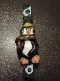 Prendedor preto decorado com pinguim